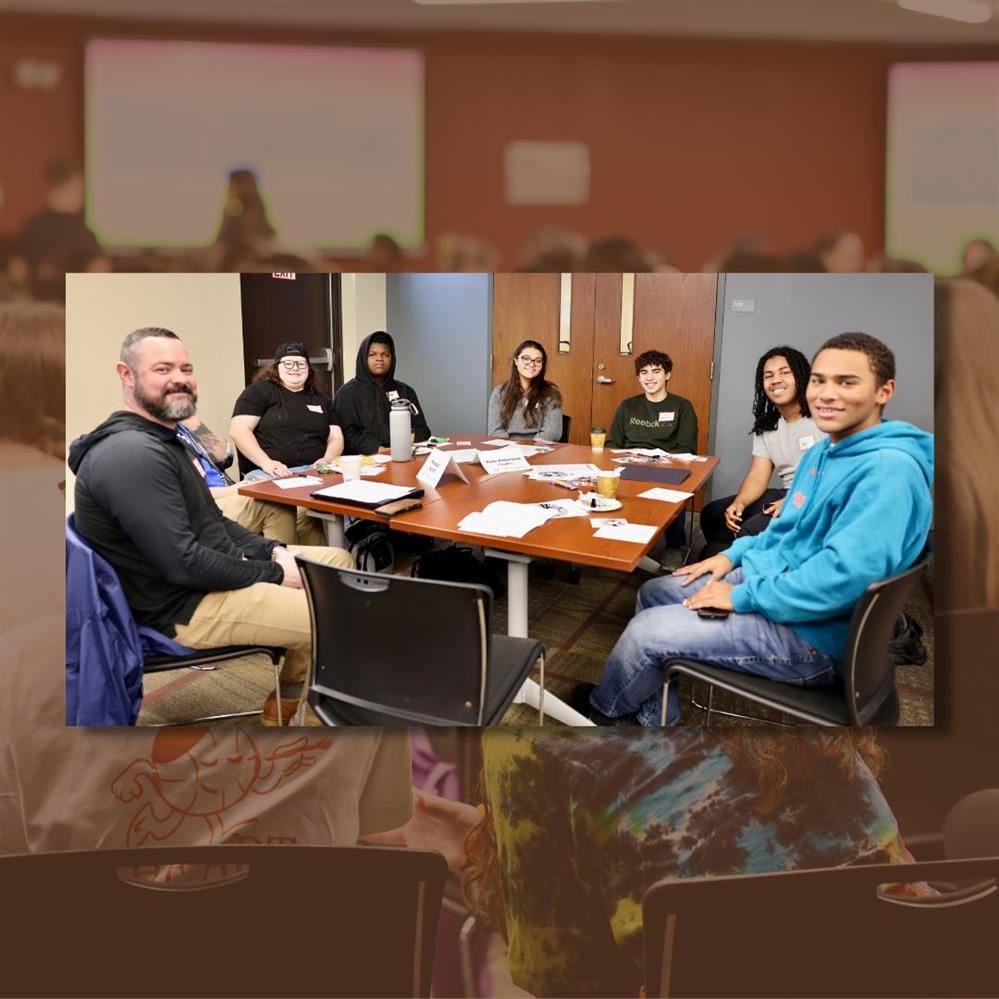  OCA students sitting at table smiling at camera